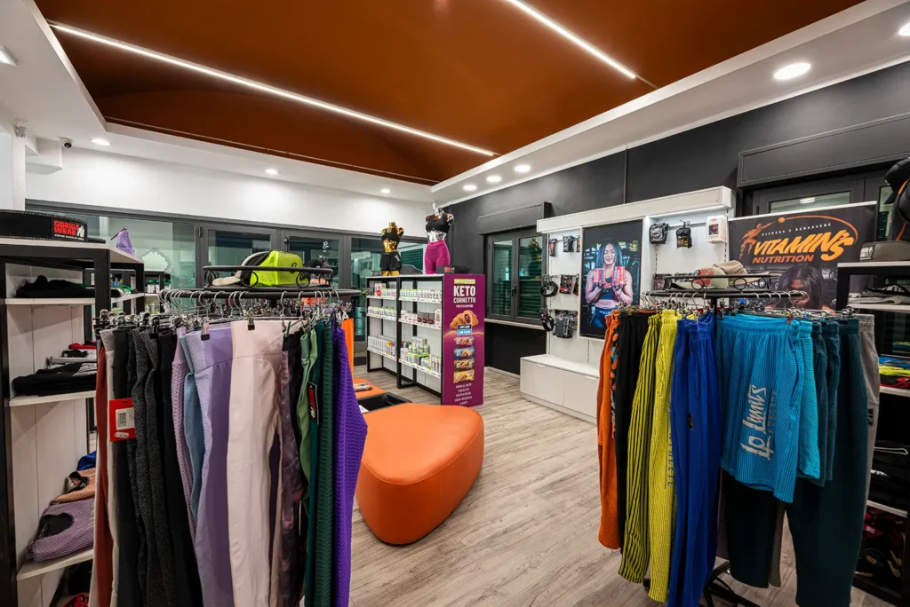 Area abbigliamento del negozio di Bastia Umbra, con capi appesi e seduta imbottita