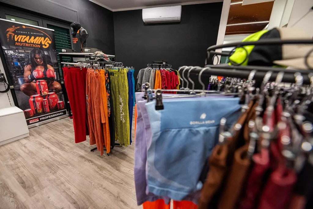 Abbigliamento sportivo appeso a una parete scura nel negozio di Bastia Umbra